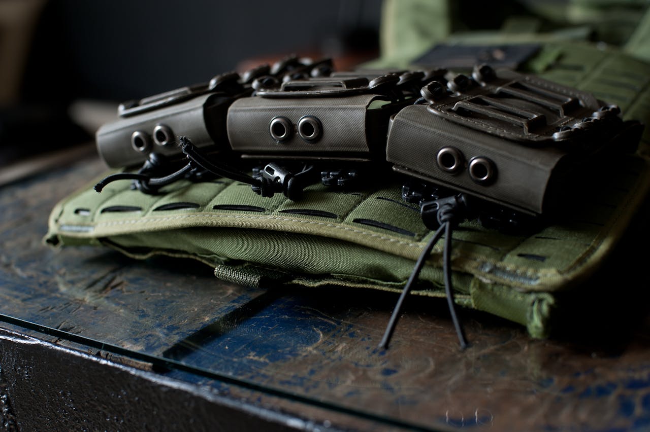 Close-up image of tactical gear and pouches mounted on a green vest.